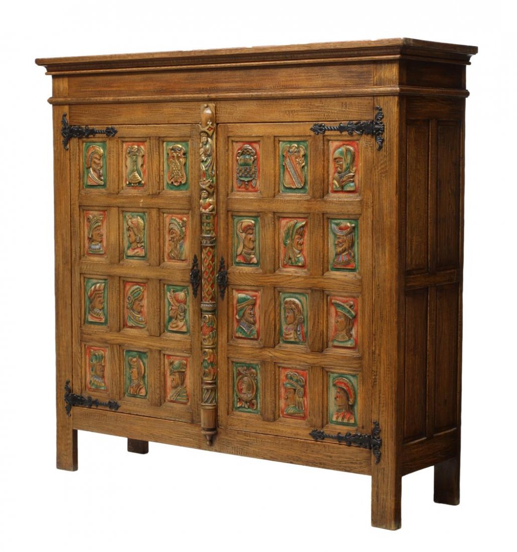 FRENCH BOOKCASE, CARVED POLYCHROME FIGURES: French Breton cabinet, last half 20th c., a protruding cornice over two wide paneled doors, each panel with a polychrome figural carved representations, interior shelves, paneled sides, rising on bloc