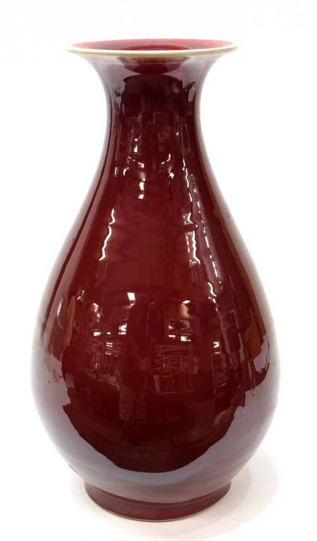 CHINESE SANG DE BOEUF OX BLOOD PORCELAIN VASE: Chinese Sang De Boeuf porcelain in ox blood red, the flared lip over an elongated bulbous body, on a short foot, approx 16.25"h, 9lbs Start Price: $100.00