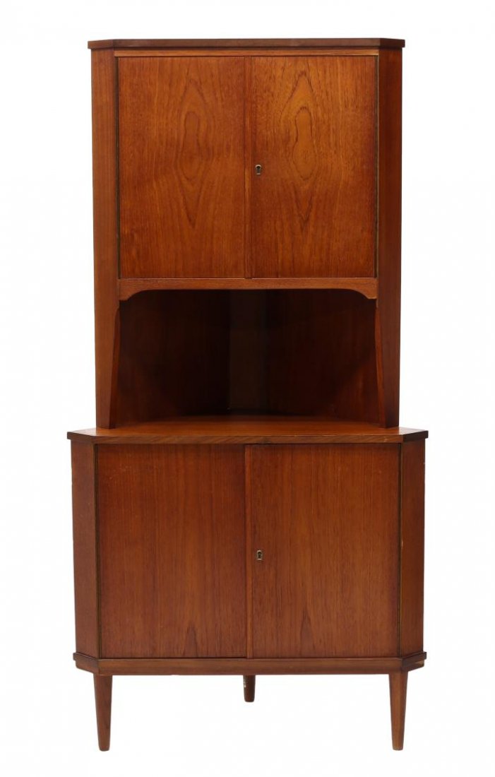 DANISH MID-CENTURY MODERN TEAK CORNER CABINET: Danish mid-century modern teakwood corner cabinet, the upper case and lower case fitted with doors opening to shelved interiors, rising on tapered legs, 65"h, 33"w, 23"d, Start Price: $100.00