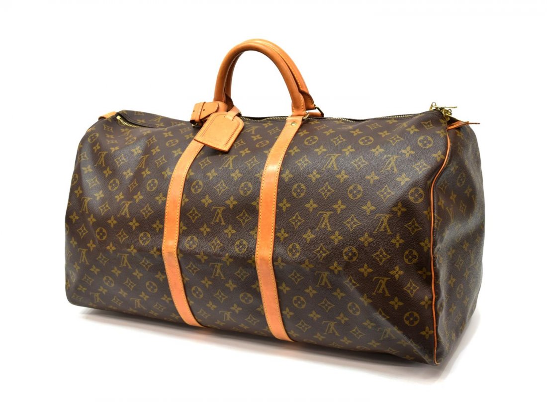LOUIS VUITTON 'KEEPALL 60' MONOGRAM DUFFLE BAG: Louis Vuitton "KeepAll 60" traveling duffle bag in monogram canvas, having leather handles, piping, and trim, gold tone hardware, zip top opens to brown fabric interior, retaining luggage tag and hand