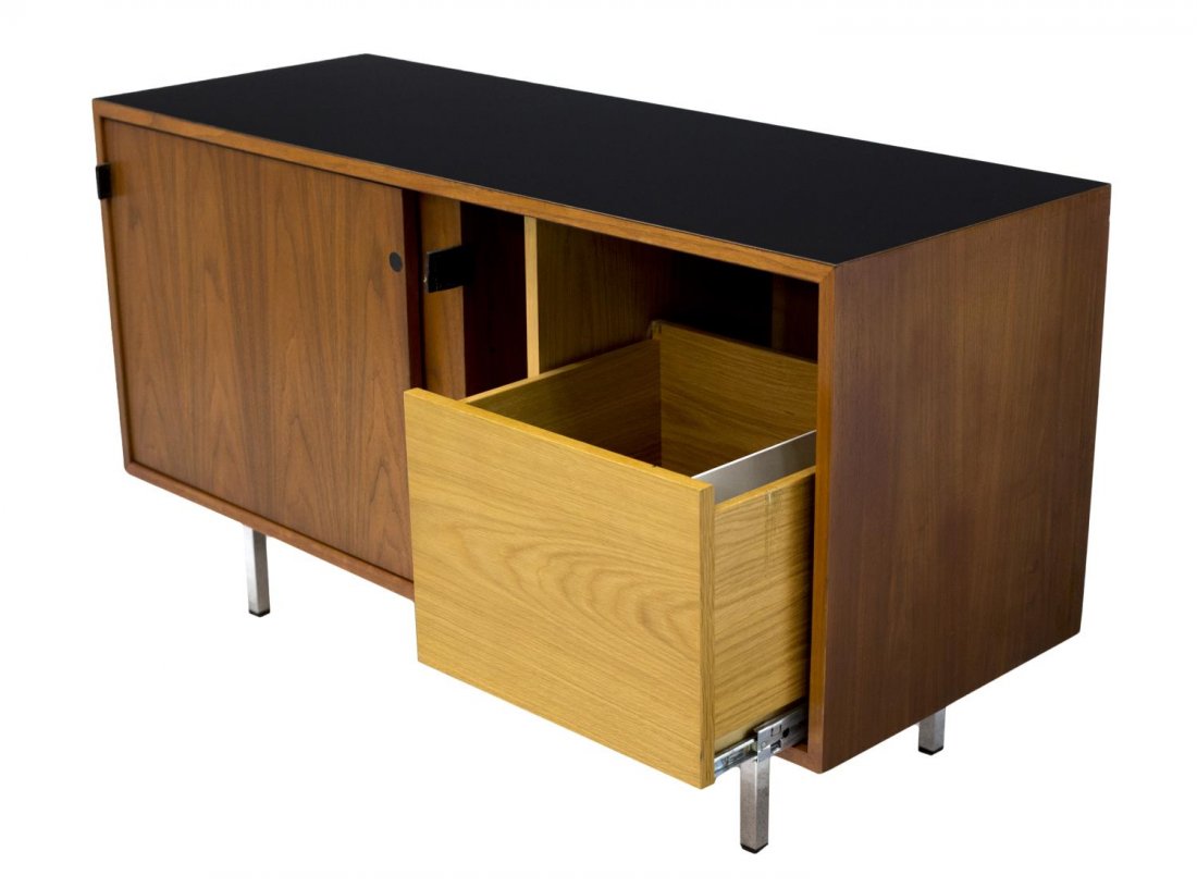 MID-CENTURY MODERN FLORENCE KNOLL CREDENZA: Florence Knoll scarce two thirds size credenza, 1960's, a black laminate top over two sliding doors with leather pulls opening to the oak interior with a slide out drawer at one side, a slide out tray