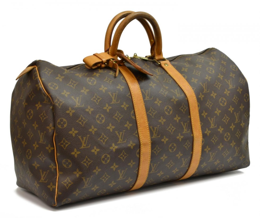 LOUIS VUITTON 'KEEPALL 50' MONOGRAM DUFFLE BAG: Louis Vuitton "Keepall 50" traveling duffle bag in monogram canvas with leather handles, piping and trim, zipped top opening to brown fabric interior, retaining luggage tag and handle strap, patinatio