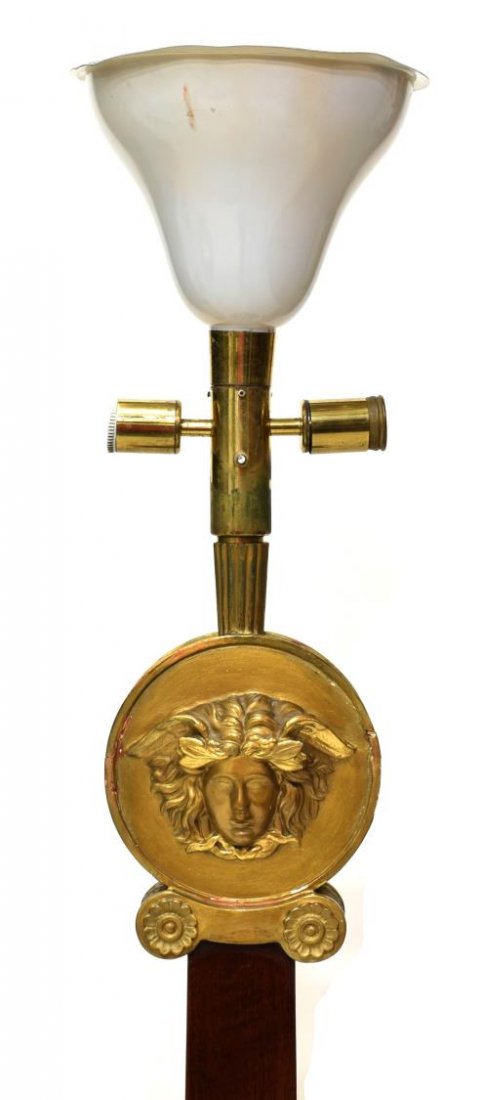 VERSACE ATTRIB MEDUSA STANDING FLOOR LAMP: Italian modern standing floor lamp, c. 1970, design attributed to Versace, a metal shade over the gilded circular image of Medusa, tapered wood standard with gilt mounting, on a circular base, some lo