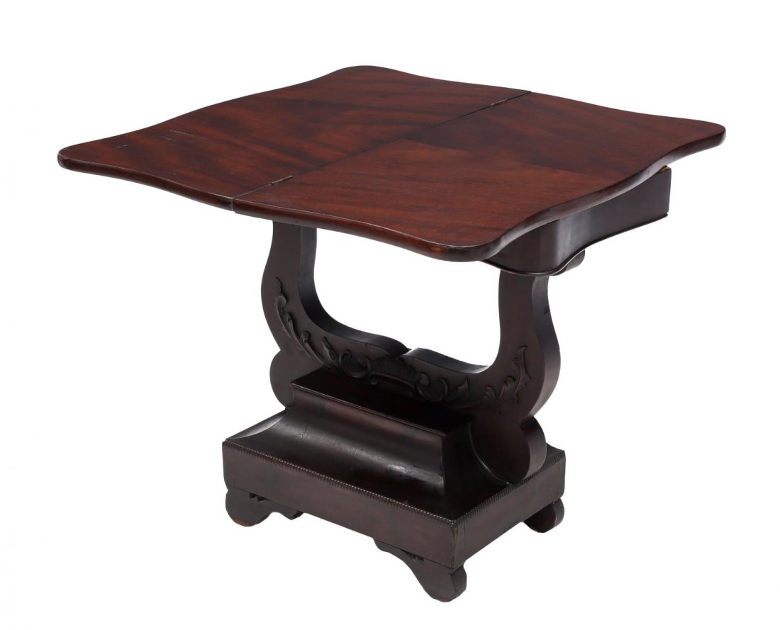 AMERICAN EMPIRE FLAME MAHOGANY FLIP GAMES TABLE: American Empire mahogany games table, c. 1850, the flip top raised on a stylized base of lyre form, veneer damage to top, table top 32.5"h, 32.5"w when open, 28"h Start Price: $100.00