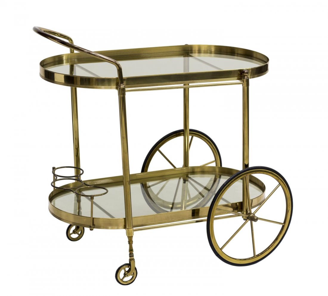 ITALIAN MID-CENTURY MODERN BRASS SERVICE CART: Italian mid-century modern brass and glass service cart, c. 1960's, two-tiers inset with smokey glass, the upper with handle, the lower fitted with bottle holders, rolling on wheels, approx 29.5"h, 29