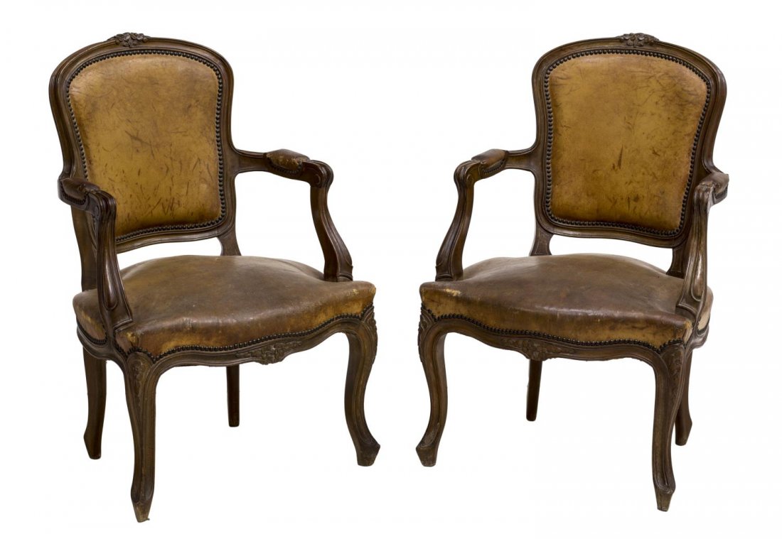 SPANISH LOUIS XV STYLE LEATHER OPEN ARMCHAIRS: Spanish Louis XV style leather open armchairs, 19th c., having a floral crest over brown leather upholstered back and seat, with nail head trim, rising on cabriole legs, 34.5"h, 23"w, 16"d Start Price