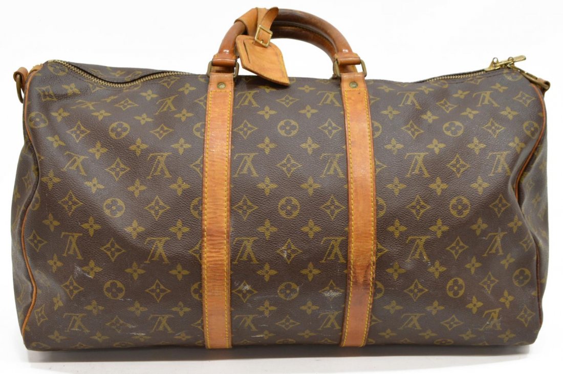 LOUIS VUITTON 'KEEPALL 50' MONOGRAM DUFFLE BAG: Louis Vuitton "Keepall 50" traveling duffle bag in monogram canvas with leather handles, piping and trim, zipped top opening to brown fabric interior, retaining luggage tag and handle strap, lacking s