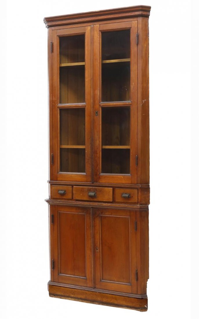 TEXAS PINE CORNER CABINET, 19TH C.: Texas pine corner cabinet, 19th c., having a stepped cornice over two glazed doors opening to shelves, three drawers, the bottom section with two doors, raised on a conforming base, 94"h, 40"w, 22"d S