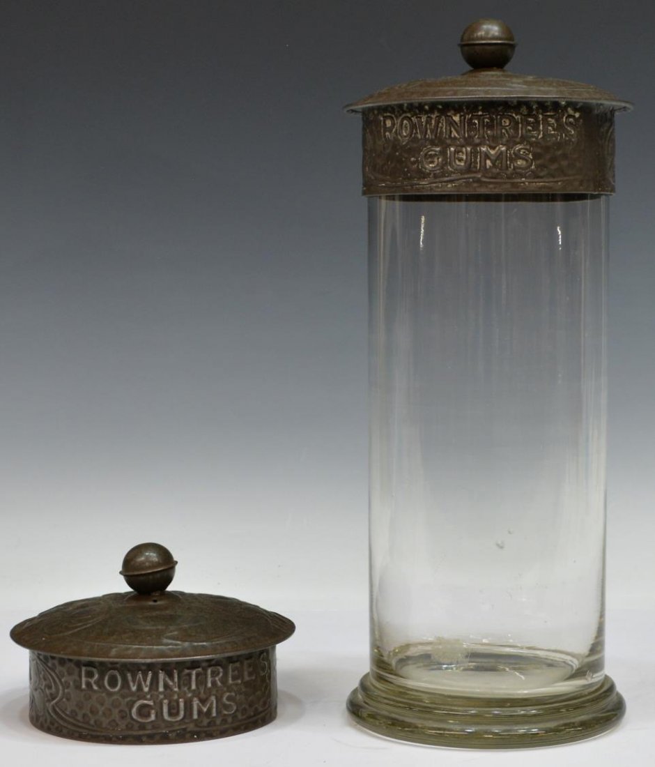 ROWNTREES GUM METAL LIDDED GLASS CANDY JAR: Glass candy jar, embossed metal Art Nouveau style lid, "Rowntrees Gum", over the tall cylindrical jar, accompanied by (1) extra lid, chips to glass rim, 13.25"h, 5.25"w, 3.75lbs *Provenance: The estat