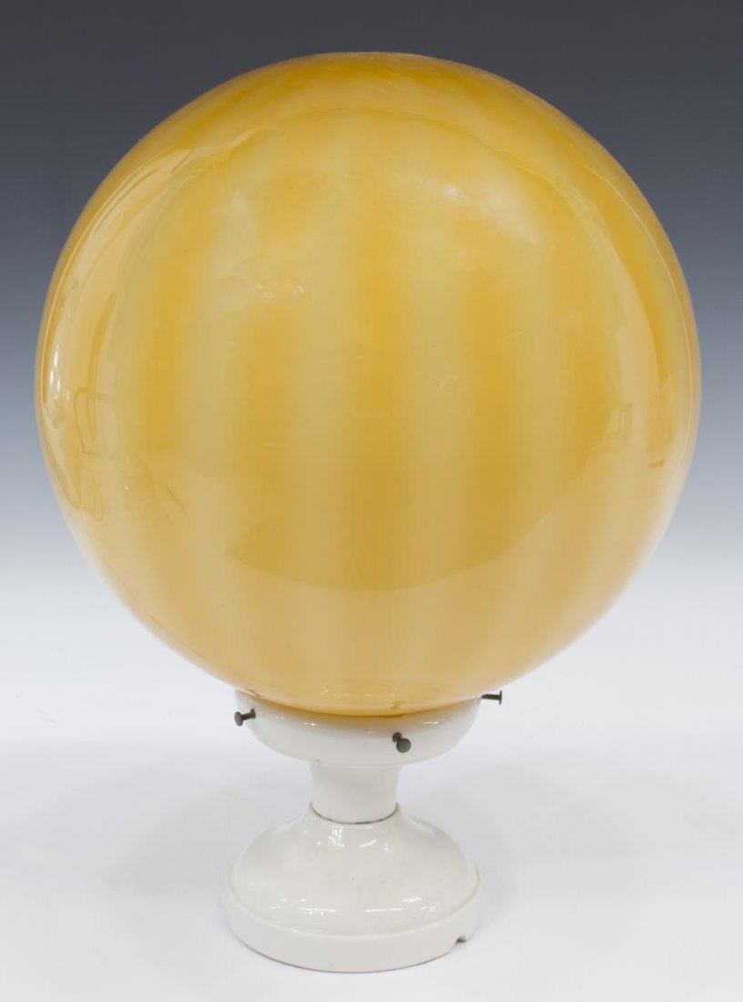 AMBER TONE GLASS & PORCELAIN SINGLE LIGHT ORB LAMP: Orb lamp, having an amber tone glass shade over a single light socket, rising on white circular foot, marked USA, 17"h, 11" diam., 6lbs Start Price: $50.00