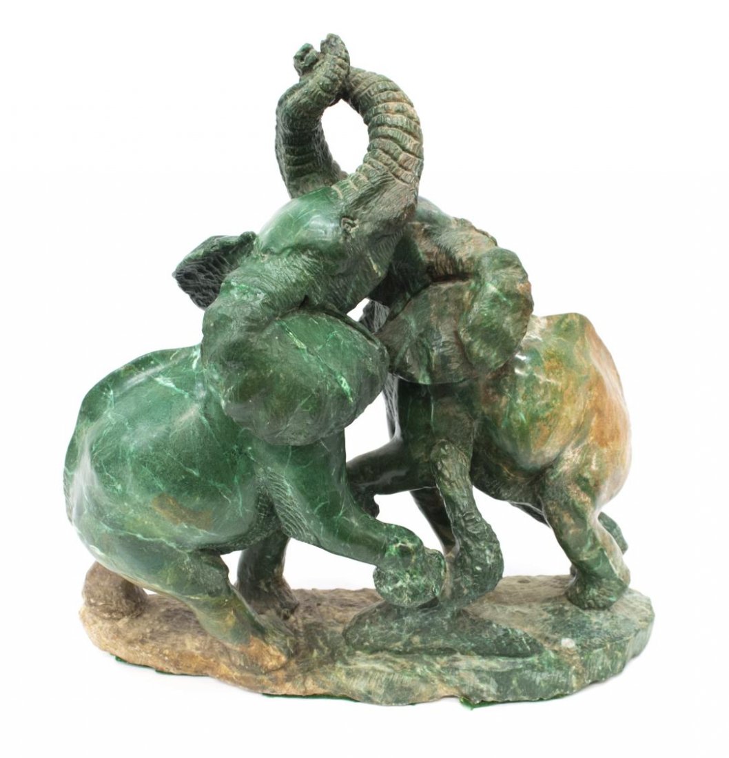 LARGE CARVED MARBLE STANDING ELEPHANTS, SIGNED: Large carved marble sculpture, Two Elephants, signed E. Kaiya (?sp), the pair in a standing pose with joined trunks, standing on a naturalistic base, green and brown tones to the stone, lacking tusks,