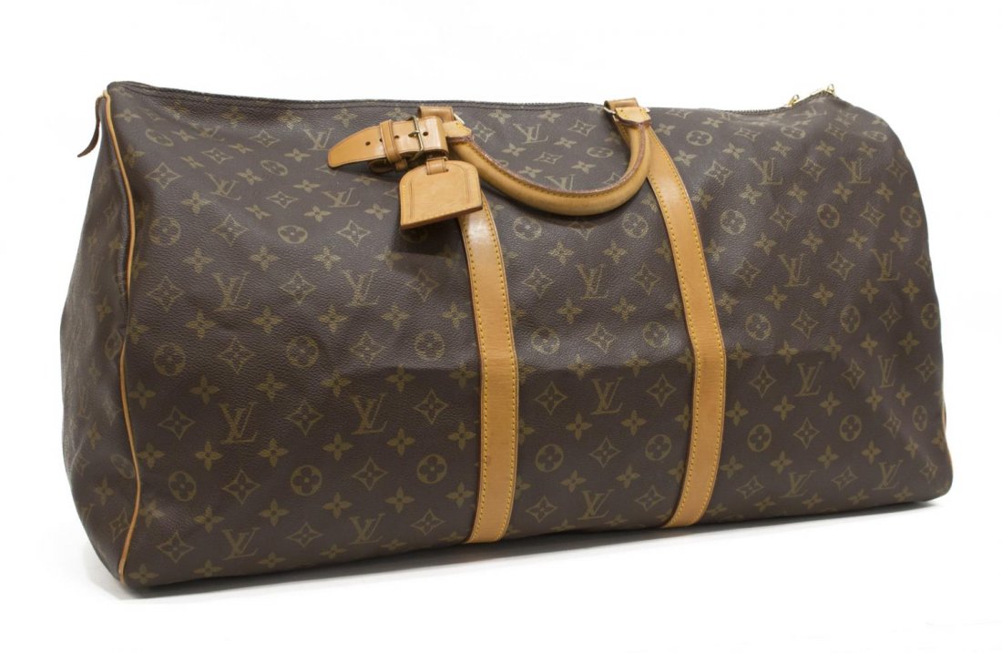 LOUIS VUITTON 'KEEPALL 60' MONOGRAM DUFFLE BAG: Louis Vuitton "KeepAll 60" traveling duffle bag in monogram canvas, leather handles, trim and piping, gold tone hardware, dual zipper top opening to a brown canvas interior, retaining luggage tag and 