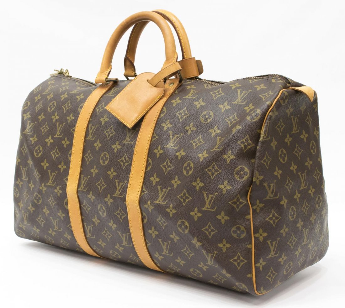 LOUIS VUITTON 'KEEPALL 50' MONOGRAM CANVAS DUFFLE: Louis Vuitton "Keepall 50" traveling duffle bag in monogram canvas, having leather handles, piping and trim, zipped top opening to brown fabric interior, retaining luggage tag and handle strap, lackin