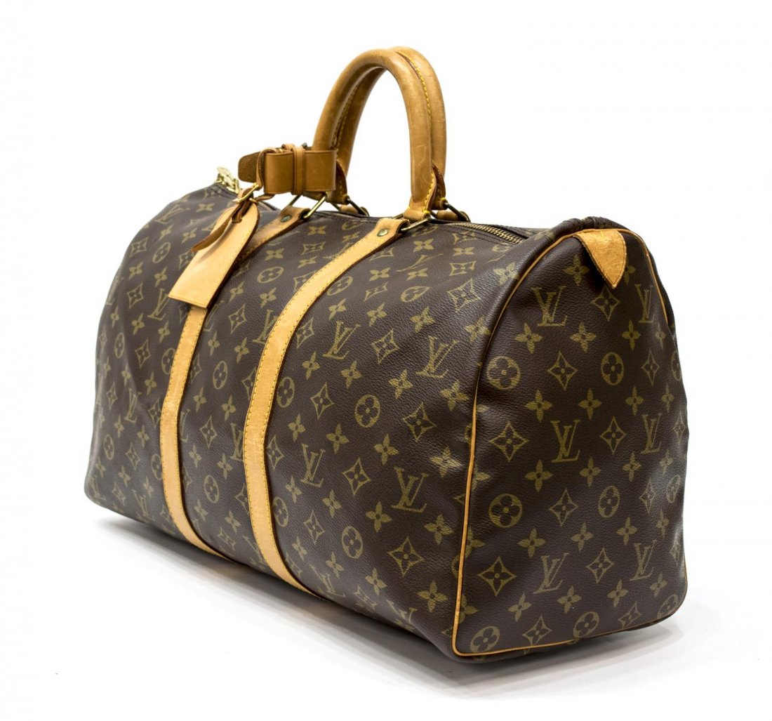 LOUIS VUITTON 'KEEPALL 45' MONOGRAM CANVAS DUFFLE: Louis Vuitton "KeepAll 45" traveling duffle bag in monogram canvas, having leather handles, piping and trim, gold tone hardware, zip top opens to brown canvas lined interior, retaining luggage tag and