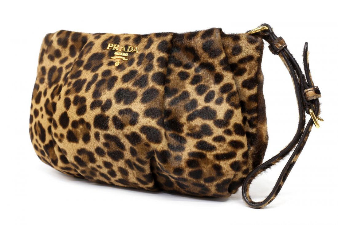 PRADA LEOPARD DYED CALF HAIR & LEATHER WRISTLET: Prada leopard dyed calf hair and leather wristlet, having gold tone hardware, zipper top opening to brown leather lined interior, single zipper pocket, bag; 6"h, 9"w, 0.25lbs *Provenance: Luxury goods