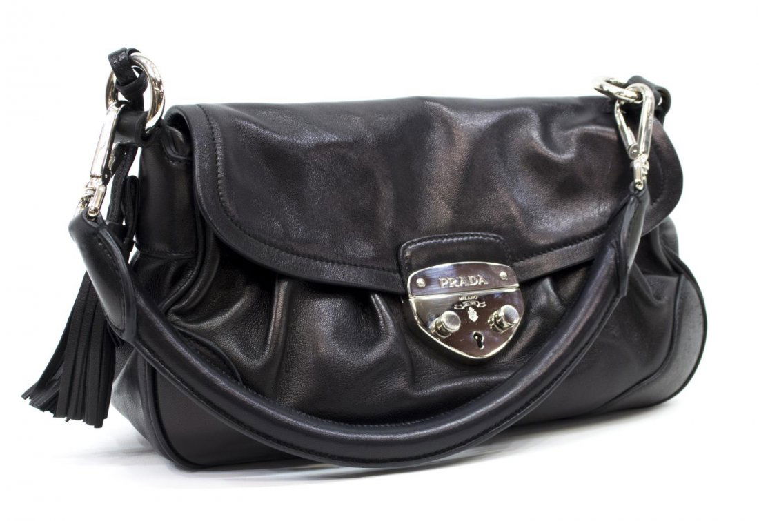PRADA BLACK NAPPA LEATHER SHOULDER BAG: Prada shoulder bag in black nappa leather, having silver tone hardware, a single roll top handle over the flap top with clasp, opening to pink leather interior with single zipper pocket, retaining tas