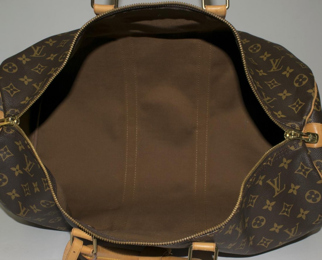 LOUIS VUITTON 'KEEPALL 50' MONOGRAM CANVAS DUFFLE: Louis Vuitton "Keepall 50" traveling duffle bag in monogram canvas with leather handles, piping and trim, zipped top opening to brown fabric interior, retaining luggage tag and handle strap, patinatio