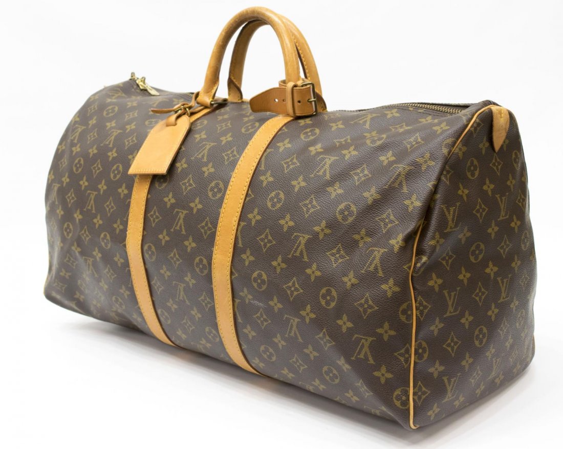 LOUIS VUITTON 'KEEPALL 55' MONOGRAM CANVAS DUFFLE: Louis Vuitton "Keepall 55" traveling duffle bag in monogram canvas, having leather handles, trim, and piping, zipped top opening to brown canvas lined interior, retaining luggage tag and handle strap,