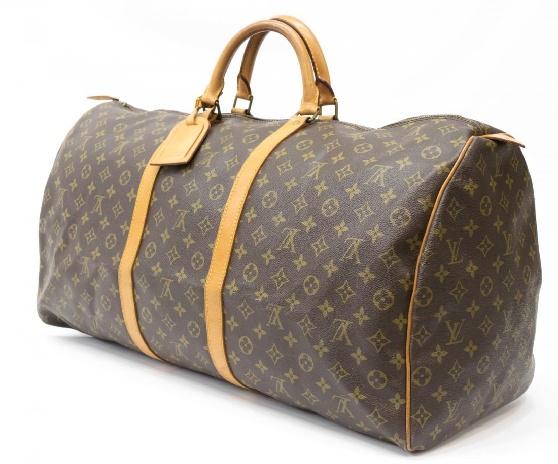 LOUIS VUITTON 'KEEPALL 60' TRAVELING DUFFLE BAG: Louis Vuitton "KeepAll 60" traveling duffle bag in monogram canvas, leather handles, piping, and trim, zip top opens to brown interior, retaining luggage tag, some patination, spotting and marks to le