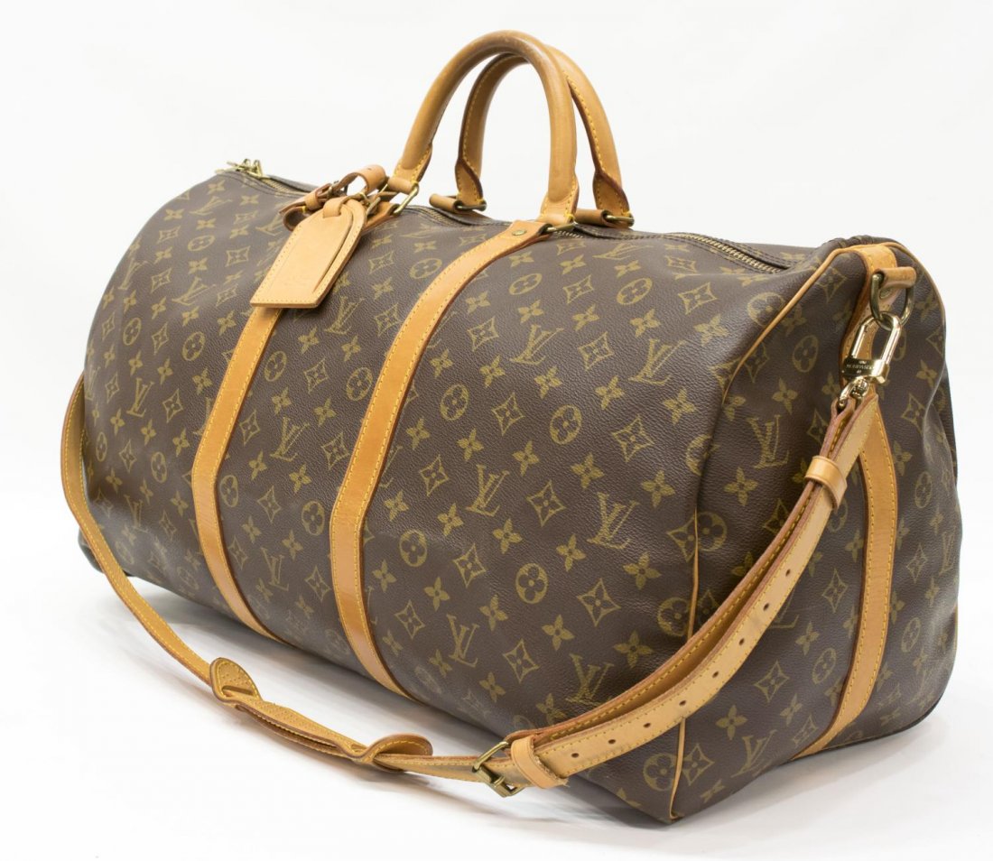LOUIS VUITTON 'KEEPALL 55' BANDOULIERE DUFFLE BAG: Louis Vuitton "Keepall 55" traveling duffle bag in monogram canvas with leather handles, piping, and trim, zipped top opening to canvas interior, retaining shoulder strap, luggage tag and handle strap