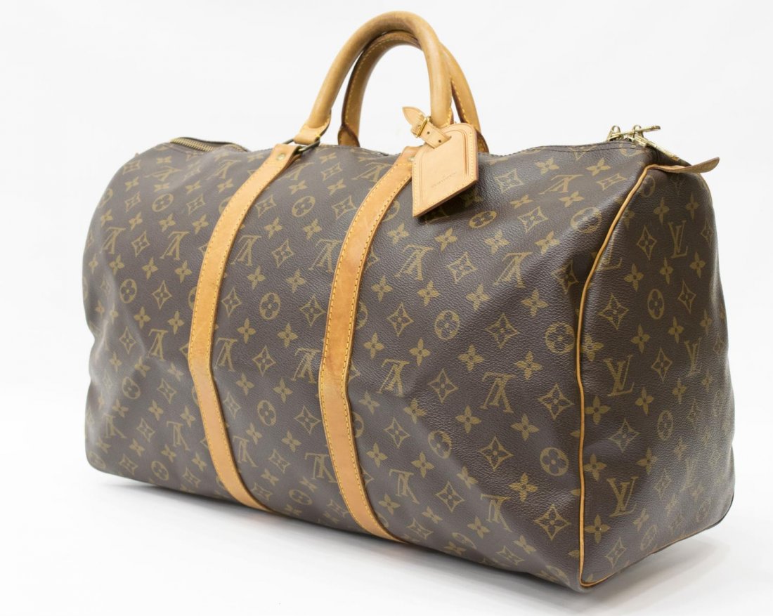 LOUIS VUITTON 'KEEPALL 50' MONOGRAM DUFFLE BAG: Louis Vuitton "Keepall 50" traveling duffle bag in monogram canvas with leather handles, piping and trim, zipped top opening to brown interior, retaining luggage tag, handle strap, creasing, patinatio