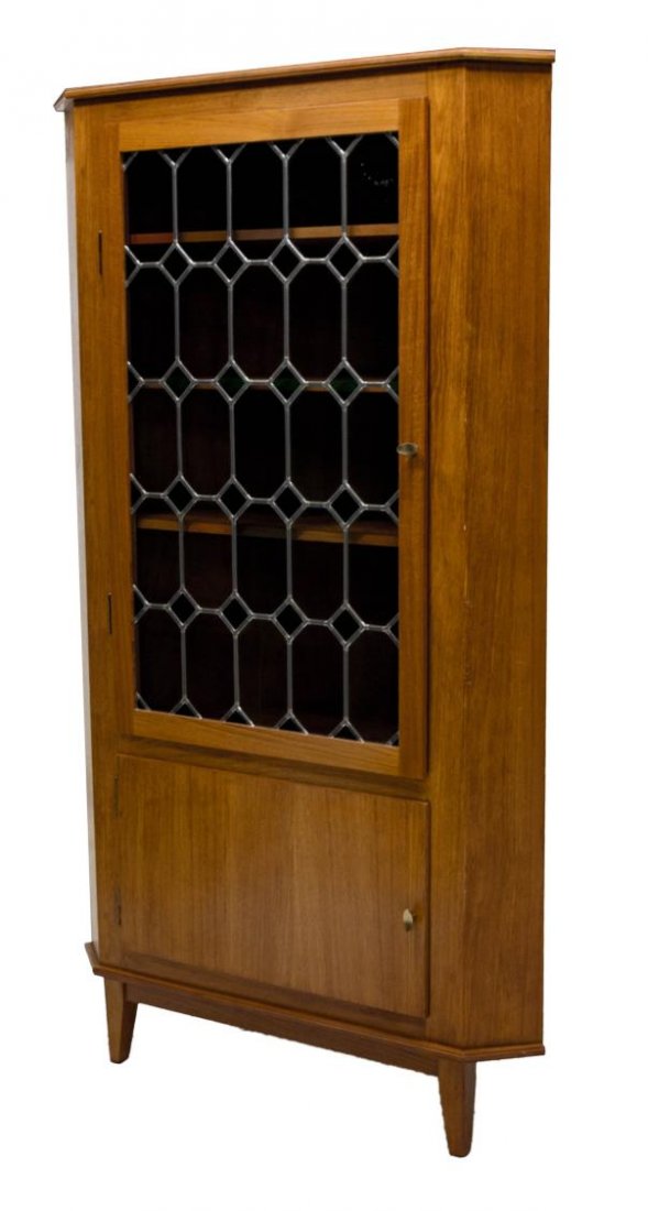DANISH MID CENTURY STAINED GLASS CORNER CABINET: Danish mid-century modern teakwood corner cabinet, c. 1960, the triangular case fitted with leaded stained glass paneled door, opening to a shelved interior, over a lower door opening to shelved inter