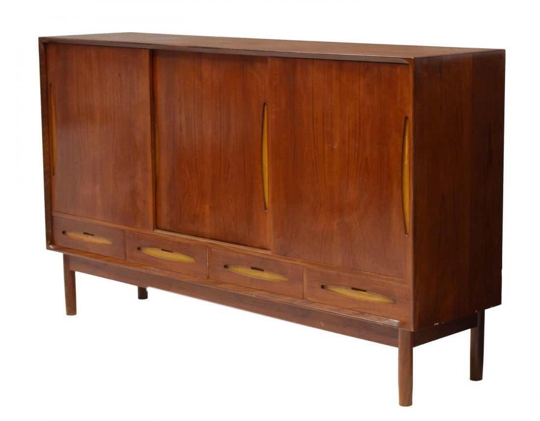 DANISH MID-CENTURY MODERN TEAKWOOD SIDEBOARD: Danish mid-century teakwood sideboard, rectangular with three sliding doors opening to shelves and drawers, four lower exterior drawers, all rising on turned supports. 41.5, 70"w, 17.25"d Start Price: