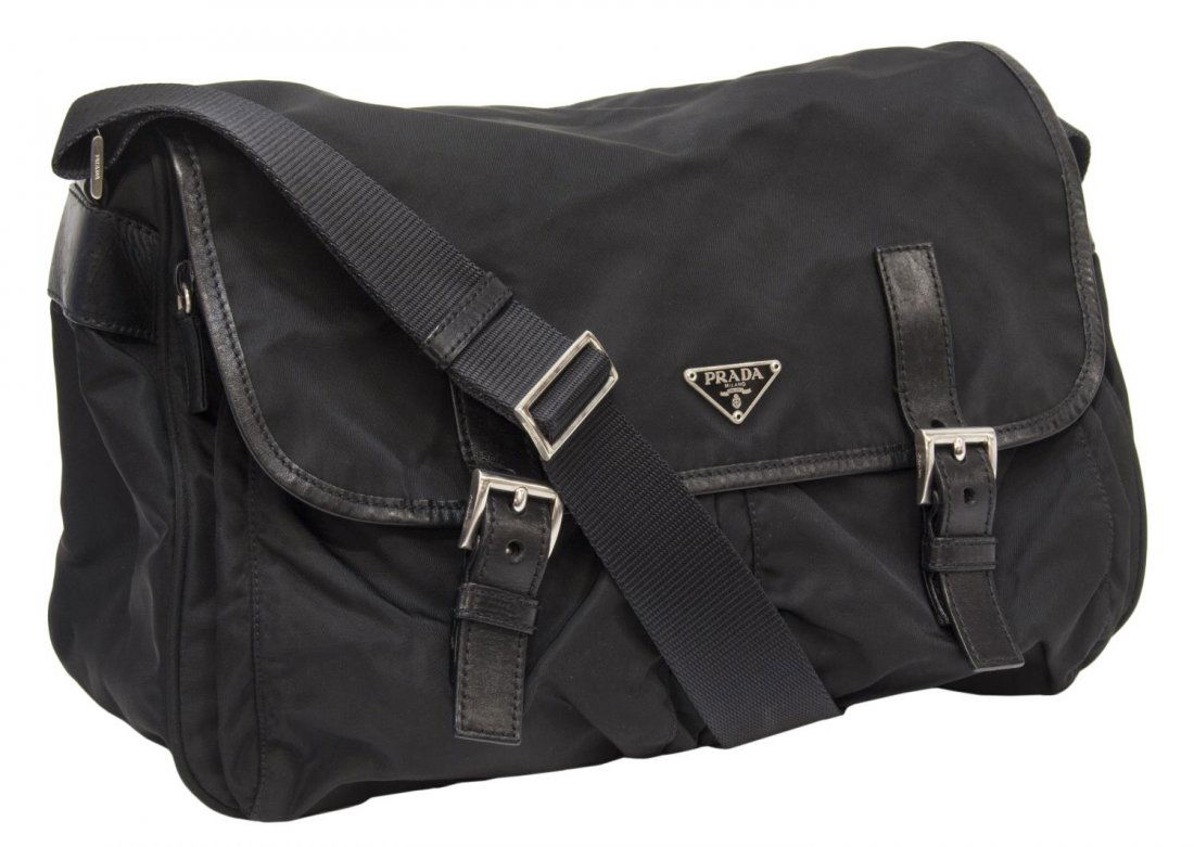PRADA BLACK NYLON SHOULDER MESSENGER BAG: Prada black nylon shoulder messenger bag, adjustable shoulder strap, leather trim and straps, silver tone hardware, dual exterior zipper slots, double buckle flap revealing a zipper top opening to a b