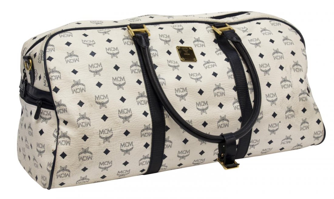 MCM MONOGRAM WHITE LEATHER DUFFLE TRAVEL BAG: MCM "Visetos" pattern white leather duffle bag, having blue logo pattern on exterior canvas, black leather handles, trim and piping, gold tone hardware, exterior zipper side slots, dual zipper top ope