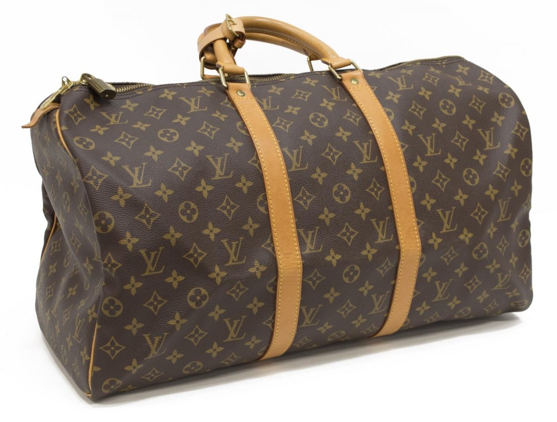 LOUIS VUITTON 'KEEPALL 50' MONOGRAM CANVAS DUFFLE: Louis Vuitton "Keepall 50" traveling duffle bag in monogram canvas, having leather handles, piping and trim, the zipped top opening to brown fabric interior, retaining luggage tag and handle strap, pa