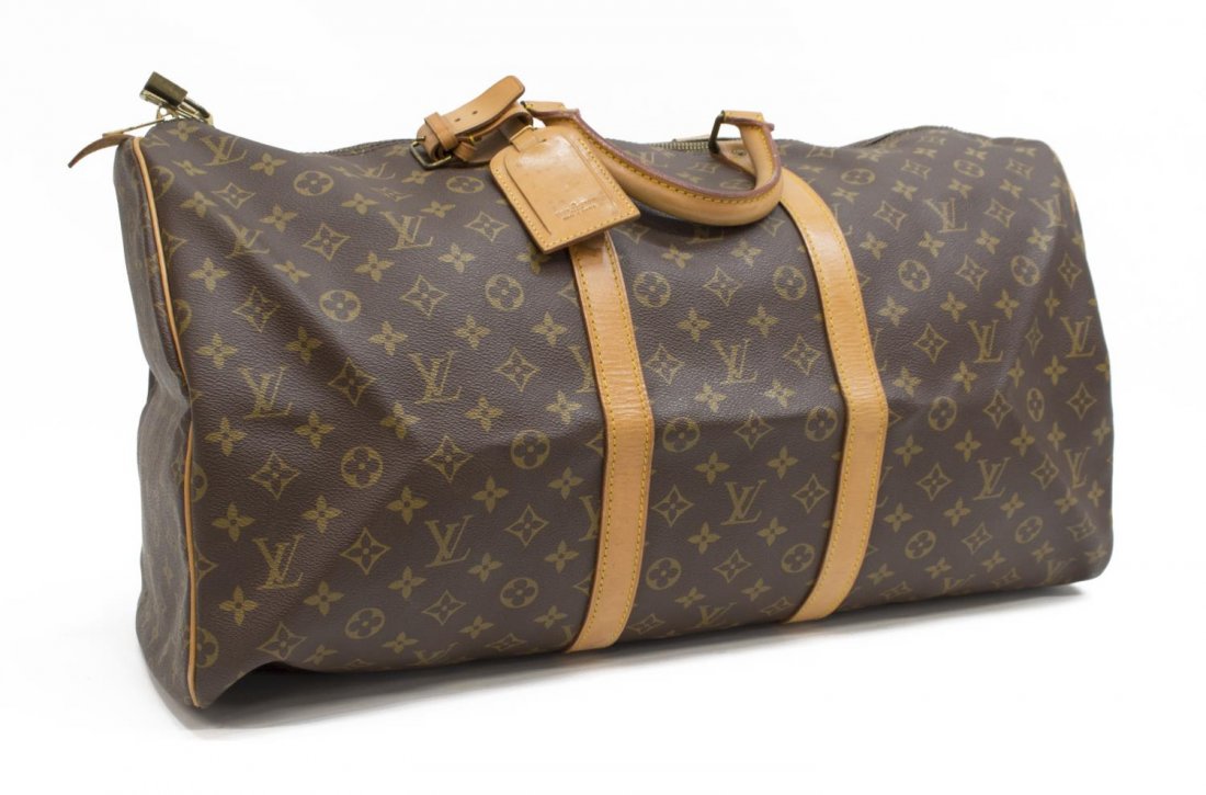 LOUIS VUITTON 'KEEPALL 55' MONOGRAM CANVAS DUFFLE: Louis Vuitton "Keepall 55" traveling duffle bag in monogram canvas, having leather handles, trim, and piping, zipped top opening to brown canvas lined interior, retaining luggage tag, handle strap, an
