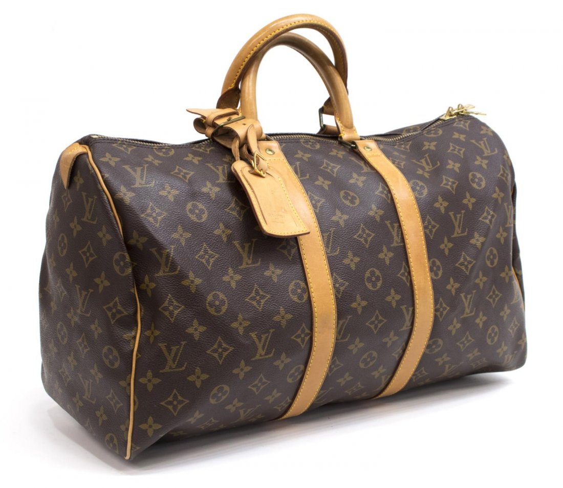 LOUIS VUITTON 'KEEPALL 45' MONOGRAM CANVAS DUFFLE: Louis Vuitton "KeepAll 45" traveling duffle bag in monogram canvas, having leather handles, piping and trim, gold tone hardware, zip top opens to brown canvas lined interior, retaining luggage tag, pa