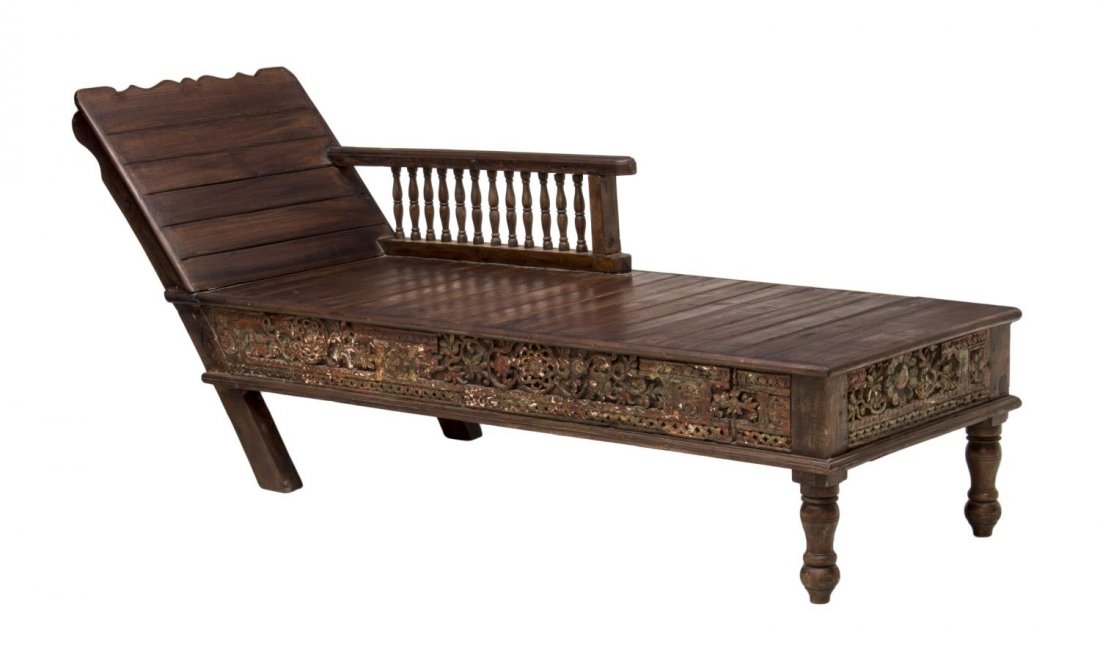 BRITISH COLONIAL TEAKWOOD LOUNGE CHAIR: British Colonial teakwood lounge chair, having a tight slat backrest and seat with one flat armrest on spindle supports, over a pierced foliate apron, rising on turned legs, 28"h, 68"w, 24"d Start Pri