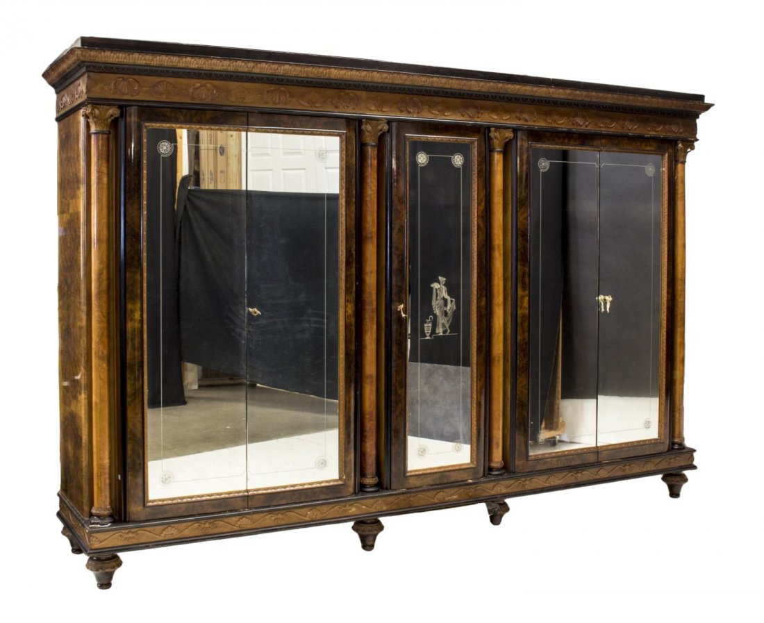 ITALIAN EMPIRE STYLE MIRRORED ARMOIRE, C. 1950S: Italian Empire style armoire, from the Milan/Meda region, c. 1950, having a corniced top over shell frieze and five mirrored and etched doors, opening to hanging interiors, column accents, flame mahog