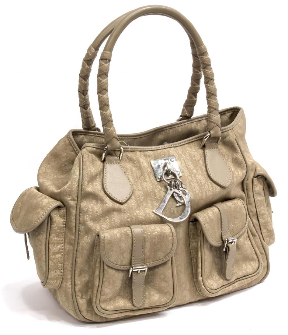 CHRISTIAN DIOR TAUPE MONOGRAM CANVAS HAND BAG: Christian Dior tote hand bag in taupe monogram canvas, taupe leather trim, silver tone hardware, having duel roll handles over the open top, vinyl lined interior with single zipper pocket, four flap p