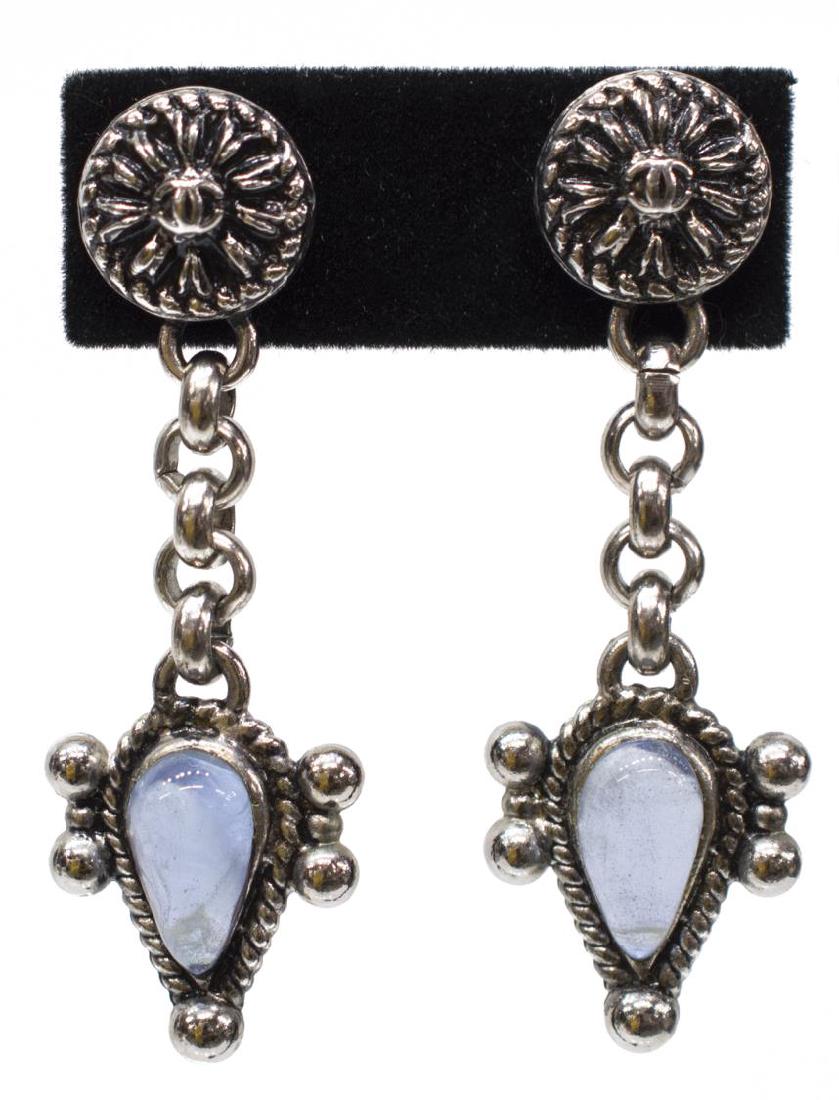 (2) VINTAGE CHANEL MOONSTONE DANGLE EARRINGS: (pair) Ladies vintage Chanel silver tone earrings, each with a post back, the front decorated with floral form centered with interlocking "CC" logo, over a short link chain issuing a cabochon teardrop