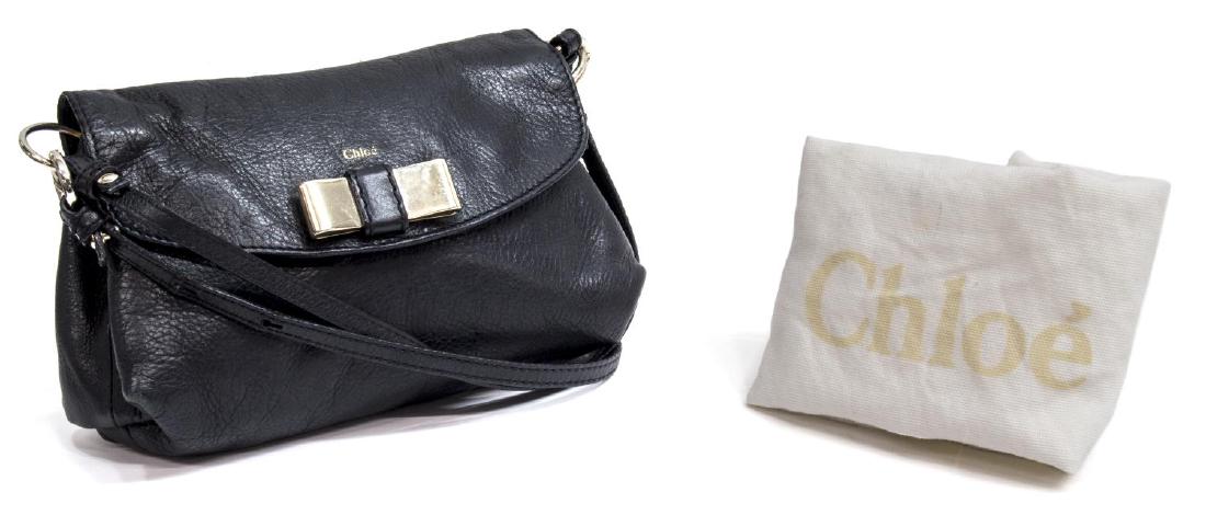 CHLOE 'LILY' BLACK LEATHER CROSS BODY BAG: Chloe "Lily" cross body bag in smooth black leather, having silver tone hardware, long shoulder strap and short carrying strap, over the flap top with metal bow, opening to lined interior with slot po
