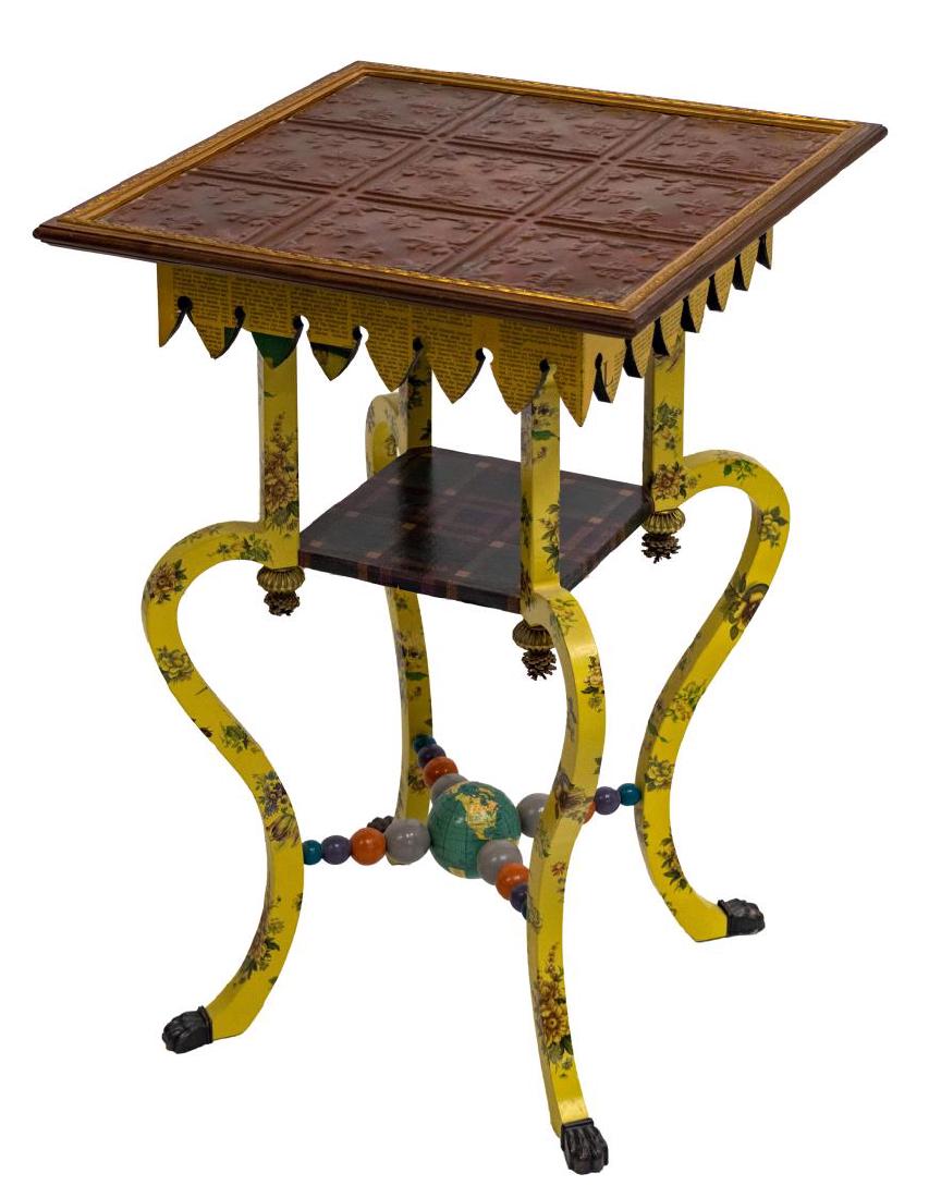 MACKENZIE-CHILDS EMBOSSED COPPER TOP WORLD TABLE: Mackenzie-Childs occasional table, having inset embossed copper top, shaped apron with news decals, over shaped floral decorated legs, plaid covered medial shelf over beaded stretcher centering a glob
