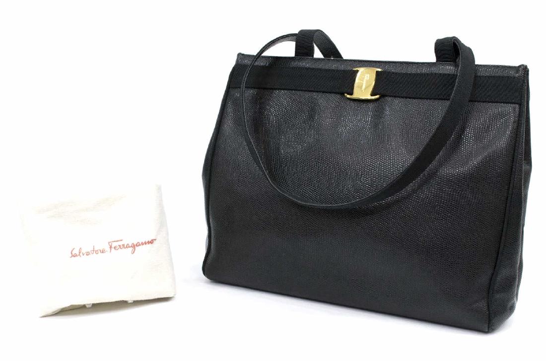 FERRAGAMO BLACK GRAINED LEATHER TOTE SHOULDER BAG: Ferragamo tote shoulder bag in black grained leather, two top handle straps, gold tone hardware, decorative strap and buckle to front, zippered pocket to interior, accompanied by dust bag, lacking pul