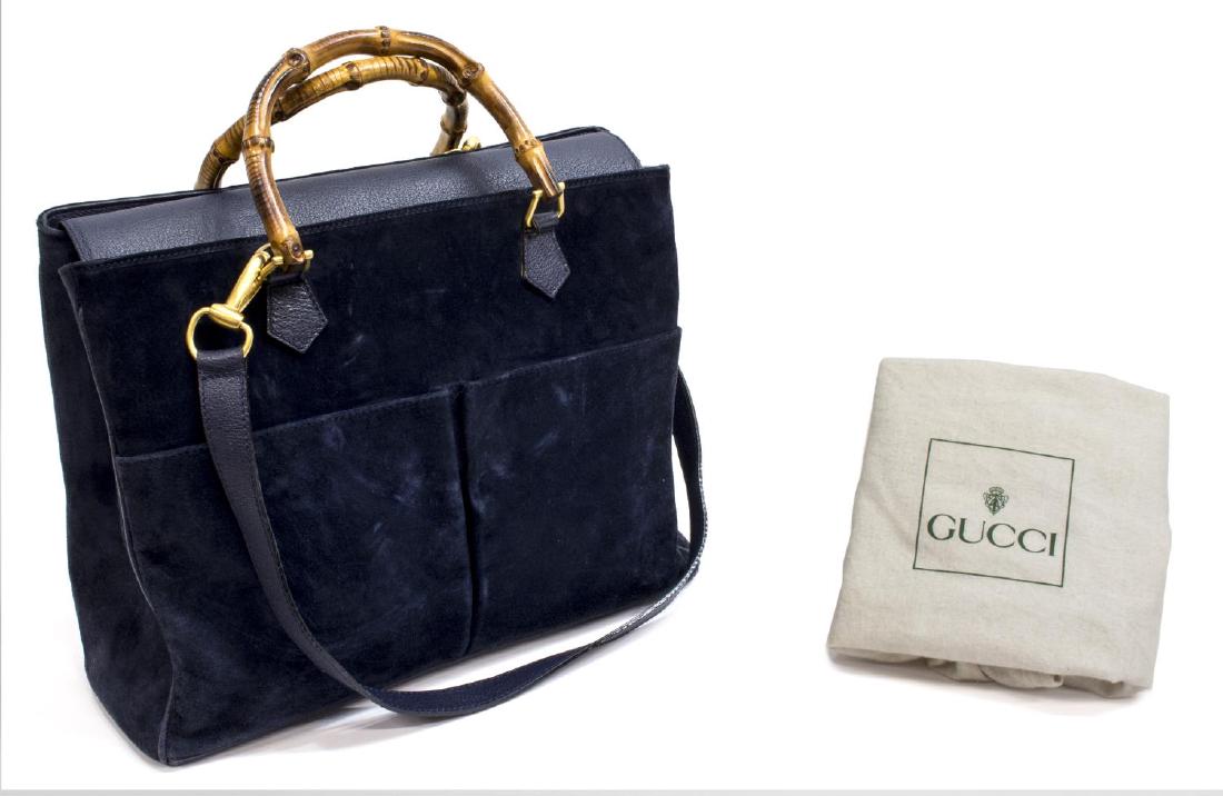GUCCI NAVY SUEDE BAMBOO HANDLED TWO-WAY TOTE BAG: Gucci handbag in navy suede, having bamboo handles and a detachable shoulder strap, leather flap top with magnetic snap closure, navy fabric interior with zipper pocket and central compartment, accomp