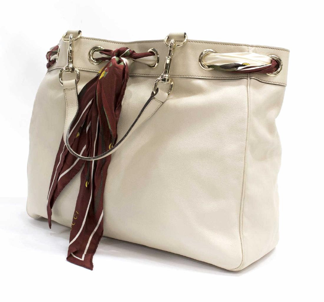GUCCI 'POSITANO' LEATHER TOTE BAG WITH SCARF: Gucci "Positano" tote bag in "Ivory" leather, a silk twill scarf in reds and creams threaded through large grommet loops at top and tied to front, two top handle straps, silver tone hardware, one zipp