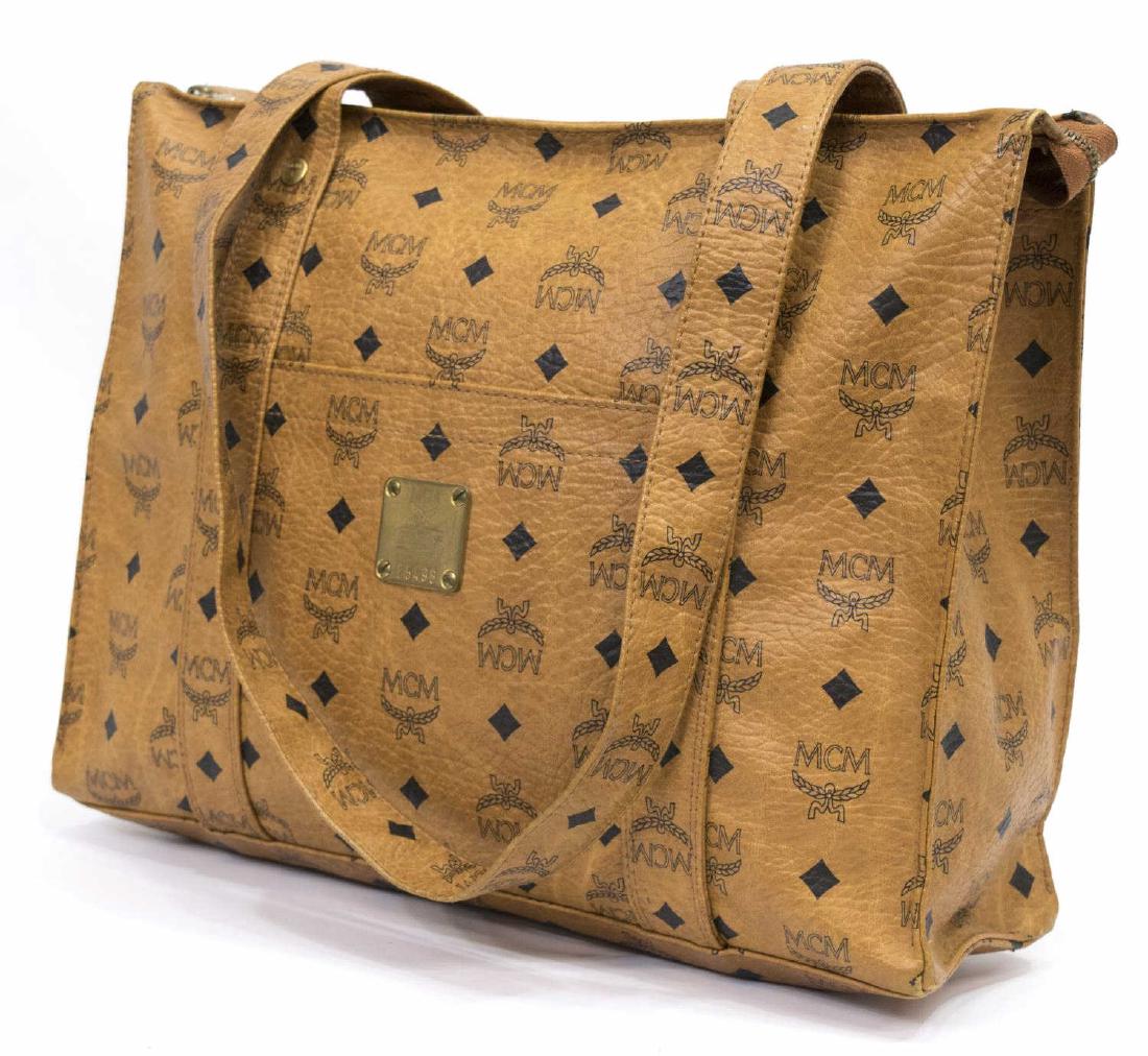 MCM BLACK ON LIGHT BROWN MONOGRAM LEATHER TOTE BAG: MCM tote bag, in monogrammed leather, slotted pocket with metal tag emblem to central front, gold tone hardware, two top handle straps, zippered hanging pocket to interior, some creasing to leather, w