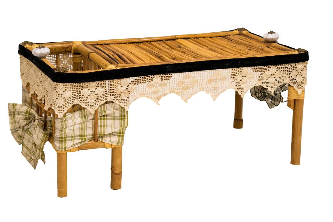 MARY KAISER LTD MOUNTED WICKER BED TRAY TABLE: Mary Kaiser Ltd wicker bed tray table, the rectangular top with open compartment to side, with lace trim, embossed brass bees at corners, 11"h, 24.5"w, 13"d *Provenance: Barnard's Antiques, Salado, Te