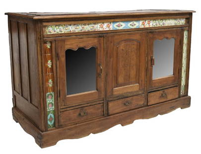 DUTCH COLONIAL TEAKWOOD & TILE SIDEBOARD, 19TH C: Dutch Colonial teakwood and tile sideboard, late 19th c., the rectangular top with iron trim, over glazed floral tile border, the case fitted with two mirrored panel doors, over three short drawers, 4