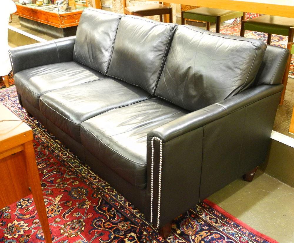 Black leather sofa garnished with tacks.: Black leather sofa garnished with tacks.