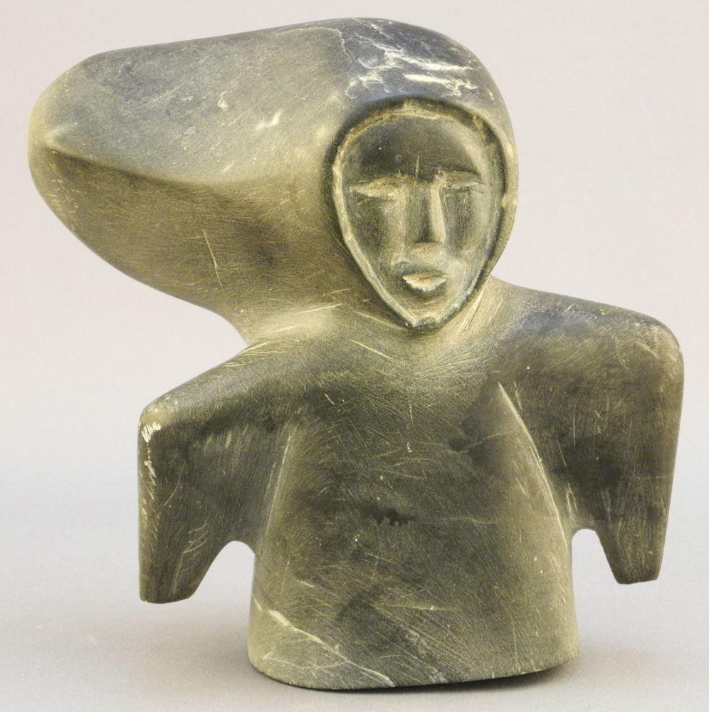 Inuit stone carving of a figure in a wind blown amauti, (1 of 5)