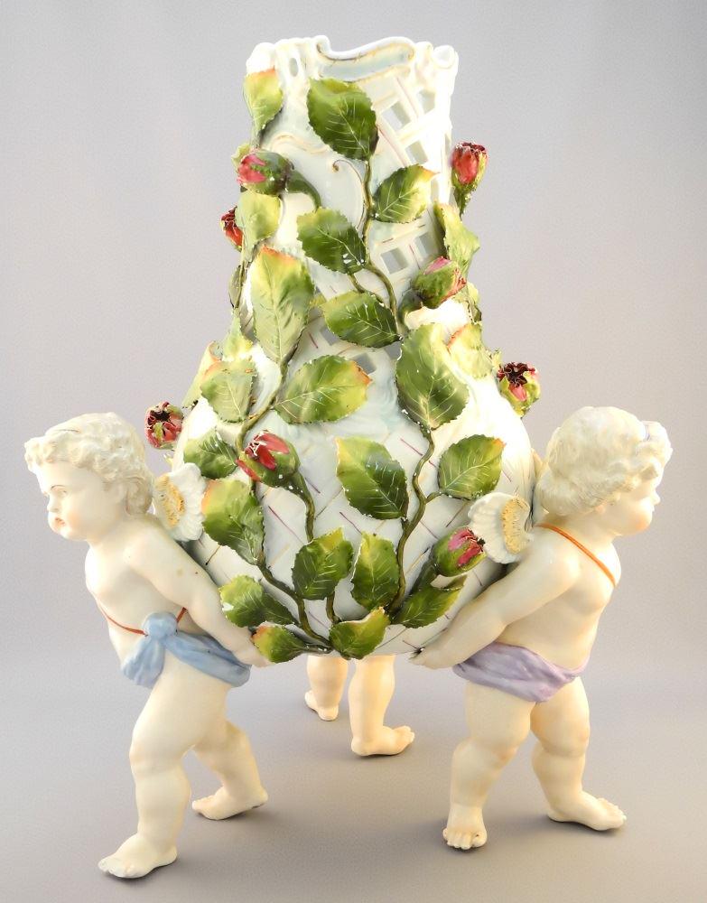 19th C Meissen porcelain floral encrusted vase held by: 19th C Meissen porcelain floral encrusted vase held by 3 Putti, 17"