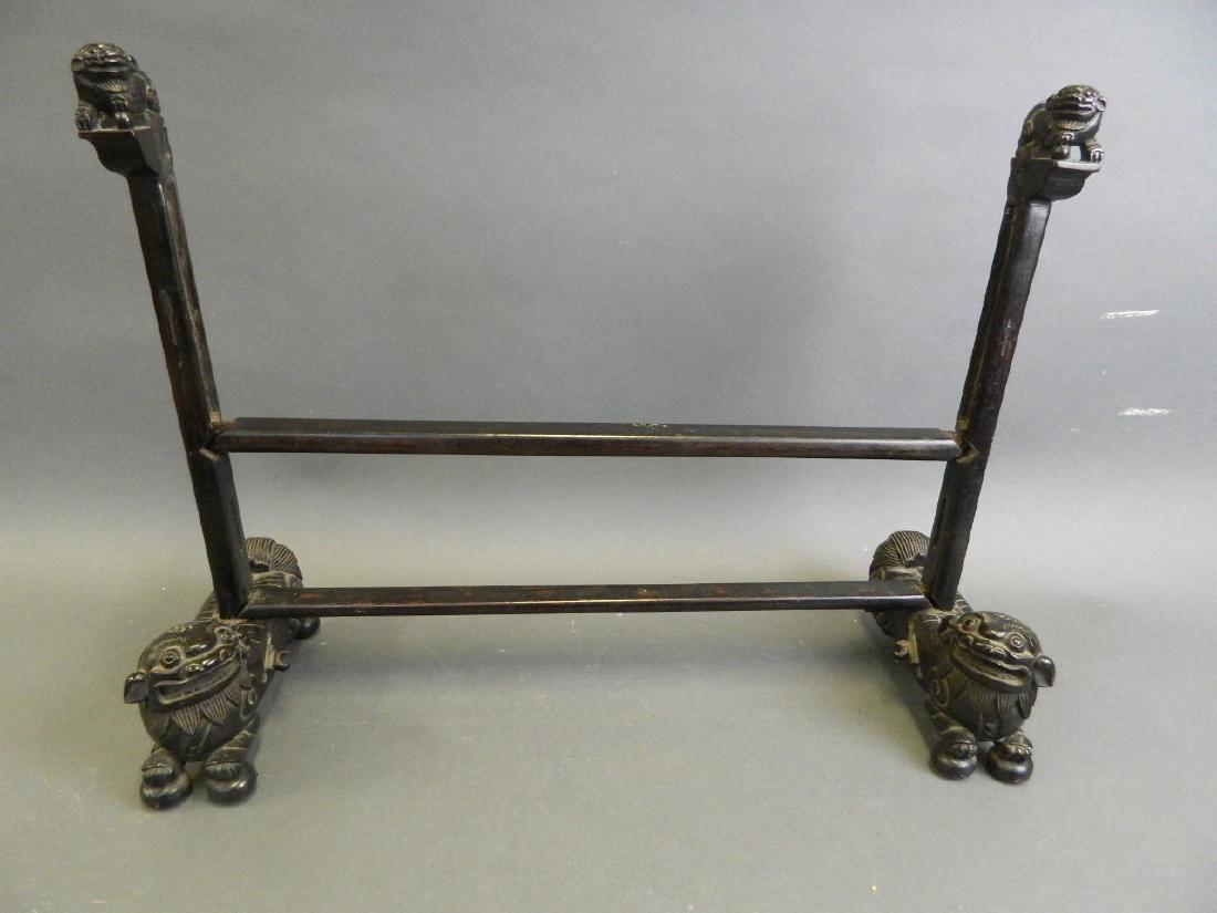 A Chinese carved hardwood screen frame, on Fo dog: A Chinese carved hardwood screen frame, on Fo dog supports, 16" high (AF)