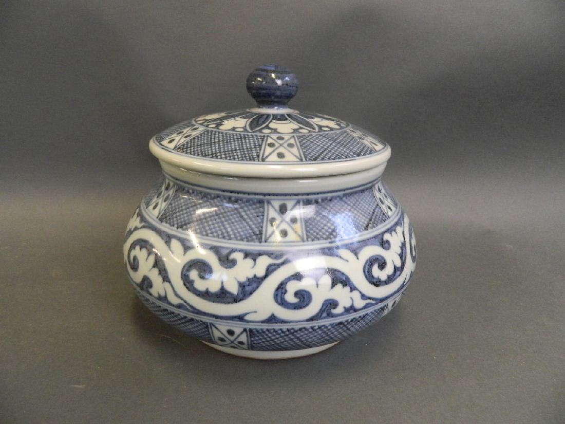 A Chinese blue and white porcelain pot and cover with: A Chinese blue and white porcelain pot and cover with stylised scrolling decoration, 6 character mark to base, 8½" diameter