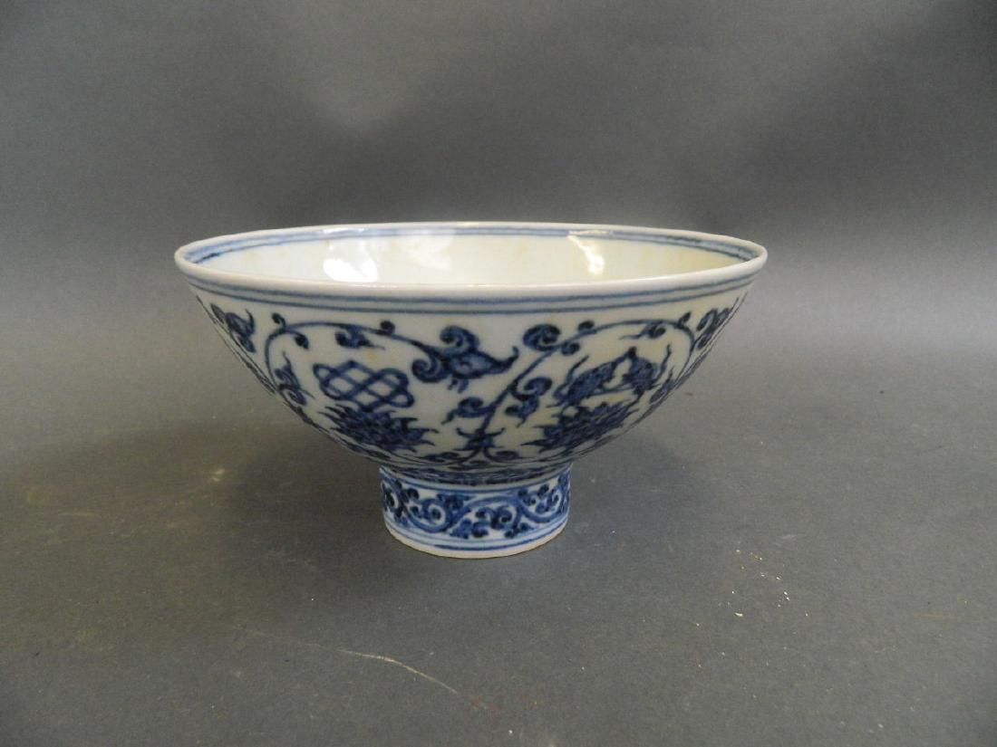 A Chinese blue and white porcelain footed bowl: A Chinese blue and white porcelain footed bowl decorated with lotus flowers and Buddhist symbols, 6 character mark, 6" diameter